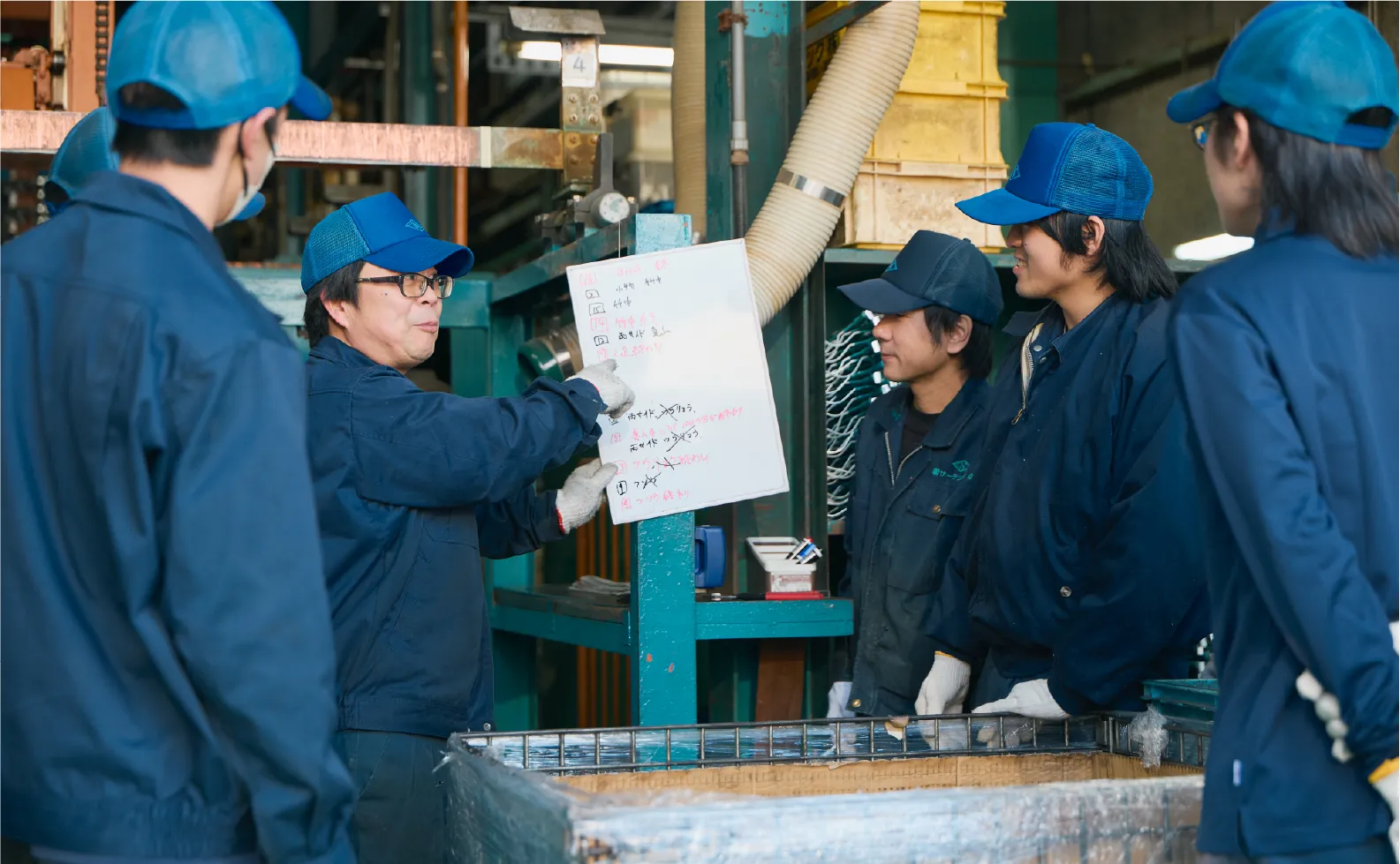 作業員を着た男性達が作業の内容を確認する様子